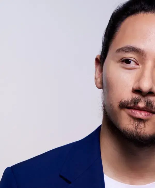 Photo of an Asian man wearing a blue sport coat and looking forward
