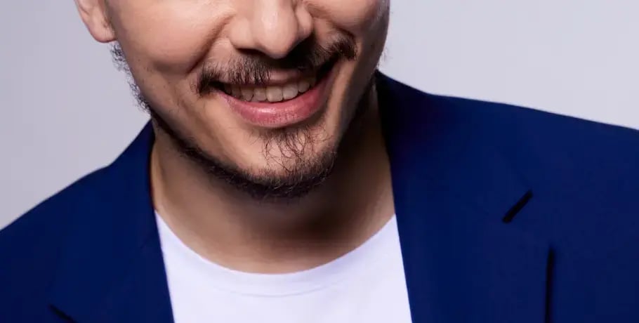 Photo of an Asian man wearing a blue sport coat and smiling