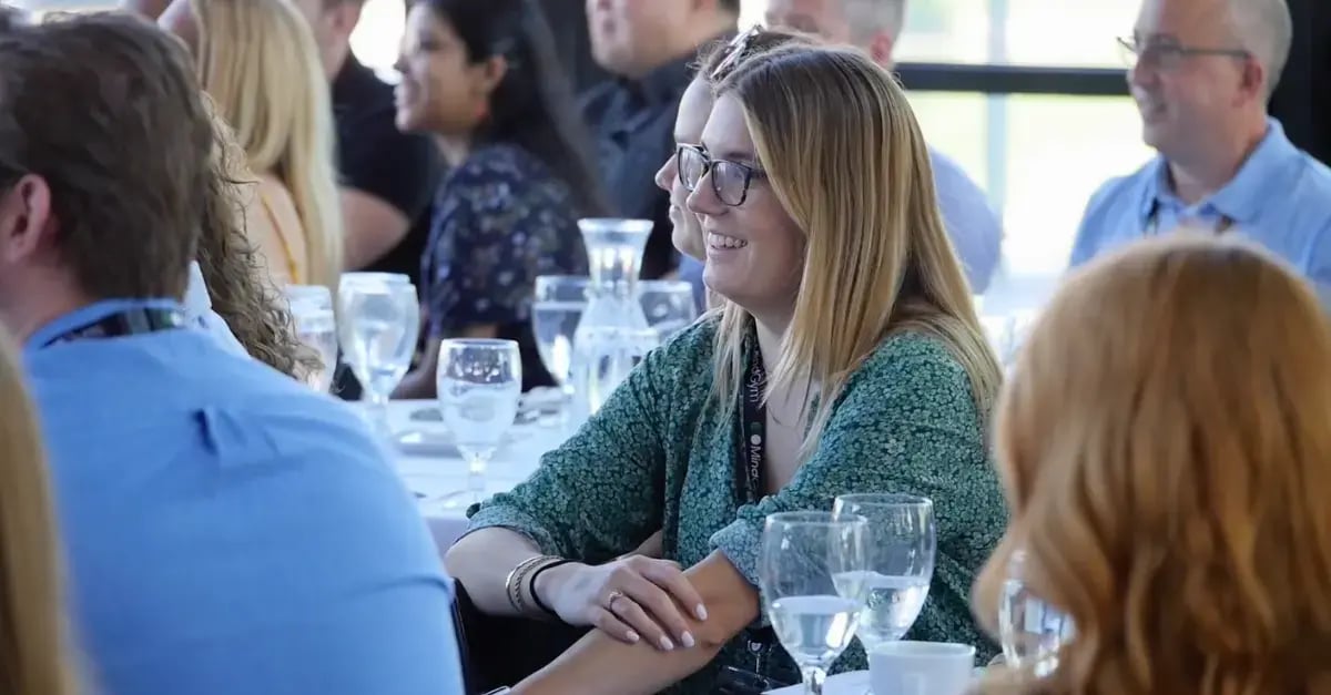 Photo of people sat at tables with glasses of water