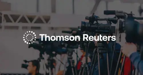 Photo of press cameras standing in a line with a white version of the Thomson Reuters logo in the middle