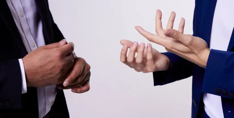 Photo of two men wearing sport coats and gesturing with their hands