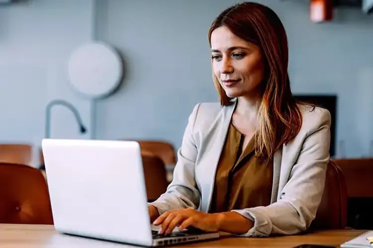 A photo of a woman say at a desk in front of a laptop computer